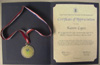[Photo:  certificate and medal]
