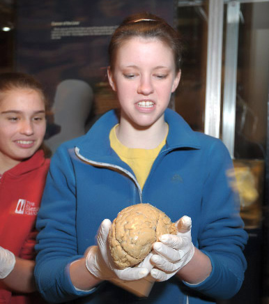A middle-school student holds the preserved brain of a 64-year-old.