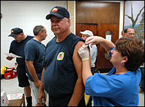 Photo of first responder being vaccinated.