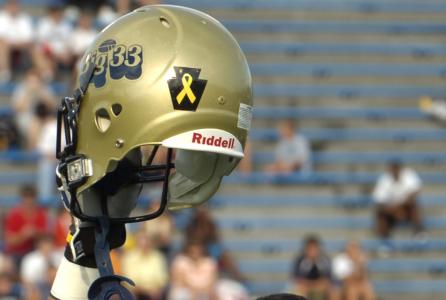 WITH golden helmets glistening in the setting mid-June sun, emotions were rising as young masters of the gridiron paid homage to Pennsylvania's fallen warriors from the Iron Division.