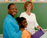 photo of teacher, parent, and student at a chalkboard