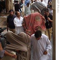 Pakistani police officers escort detained militants, faces covered with cloths, to produce them into Anti Terrorism Court in Karachi, Pakistan, 24 Aug 2009