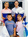 A mom, dad, son and daughter separating their trash and recycling.