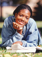 A girl reading a book on the lawn