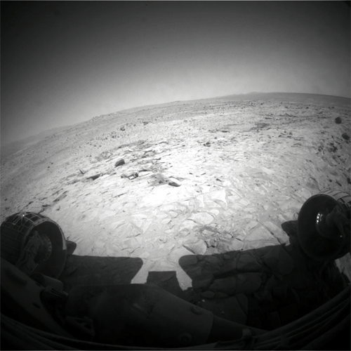 This animated gif is a combination of two still images. The first image shows the slope in front of Spirit. The rover's previous tracks are off to the left instead of directly in front of the rover.  The second image shows the rocky outcrop at the edge of Home Plate stretching away to the rover's right, from the bottom to the top in the middle of the image frame. The top of Home Plate is tilted downward to the left relative to the rover's navigation camera as Spirit tilts in the opposite direction (to the right) while driving upslope.