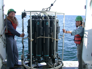 NOAA scientists deploying the Conductivity, Temperature and Depth (CTD) rosette with water sampling bottles attached.