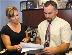 Julie Wilbanks, family readiness trainer, Marine Corps Family Team Building, Marine Corps Community Services, MCLB Albany, Ga., reviews preparations for a Family Readiness Assessment Tool survey with Richard Walker, family readiness officer, Family Readiness Command Team, MCLB Albany. Eligible Marines and their spouses may access the survey beginning Monday.