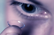 Woman putting contact lens into her eye