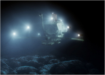 Light-equipped booms on Alvin illuminate the sea floor and pillow lava formations created by eruptions on the Mid-Atlantic Ridge.
