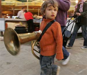 A boy carries a brass instrument during the annual brass band festival in Guca, Serbia, August 5, 2005. [© AP Images]