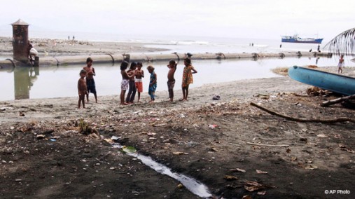 People living in a ramshackle camp bathe in Solomon Islands' capital, Honiara, July 27, 2003. [AP]