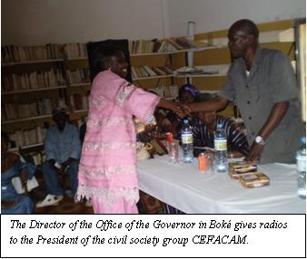 The Director of the office of the Governor in Boke' gives radios to the President of the civil society group CEFACAM