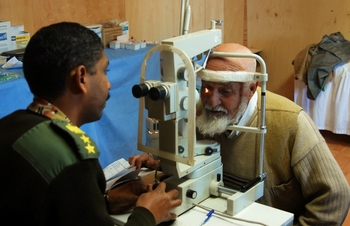 BAGRAM, Afghanistan - Egyptian Col. Ehab Foad, an ophthalmology consultant, checks a patient’s eye for cataracts and other abnormalities at the Egyptian Field Hospital.  The Egyptian Field Hospital offers medical services for Afghan citizens.