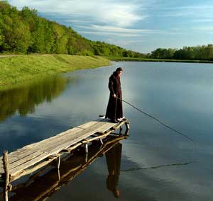 A monk fishes at a lake in Kitzkani, Moldova, May 5, 2005. [© AP Images]