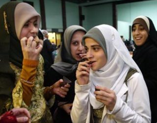 A group of young girls break fast before saying prayers at the American Muslim Union annual Ramadan dinner at Islamic Center of Passaic County in Paterson, New Jersey. (AP Images)