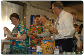 OPM Director John Berry and Secretary of the Interior Ken Salazar have fun while helping Deputy Secretary of Agriculture Kathleen Merrigan (left) and Secretary of Transportation Ray LaHood (right) pack up food for delivery in the Capitol area. [Photo by Tami A. Heilemann - DOI] 