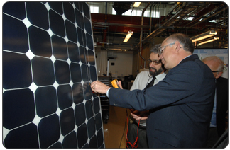 Secretary Salazar checks a photovoltaic module with a voltmeter during his visit to the Abound Solar panel plant (photo credit: Tami A. Heilemann - DOI)