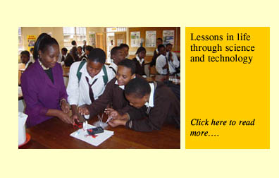 Picture of a teacher with her students and a link to her success story: Lessons in Life Through Science and Technology