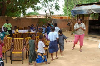 Ambassador Allen leads the children in a game of musical chairs.