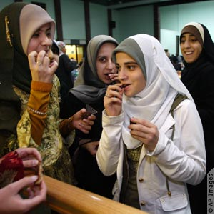 A group of young girls break fast before saying prayers at the American Muslim Union annual Ramadan dinner at Islamic Center of Passaic County in Paterson, New Jersey… (AP Images)