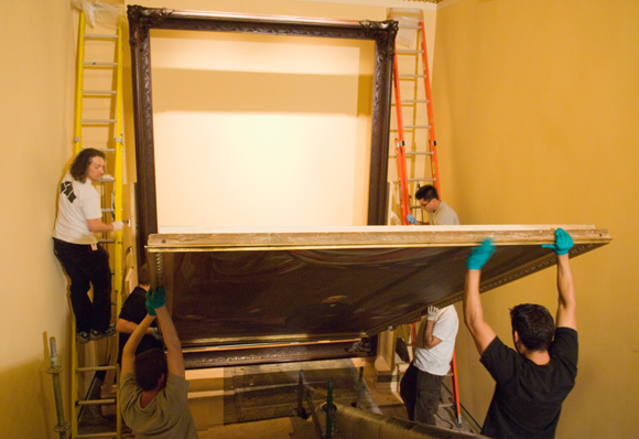 Separated for nearly half a century in storage, the massive frame is assembled and the painting then installed. 