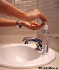 A photograph of a person washing hands with soap