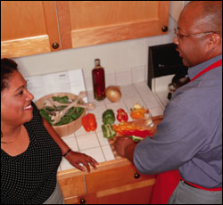 Foto: un hombre y una mujer que preparan una ensalada saludable.
