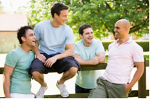 Four guys sitting on a fence