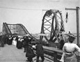 View of a roller coaster with a loop in the track, and onlookers in the foreground