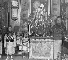 Photo: A Chinese man with 3 children in an elaborately decorated shop.