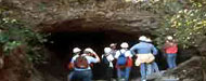 Tourist going into a dark cave.