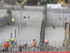 Construction workers pour concrete mix containing fly ash.