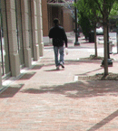 Man Walking on Sidewalk