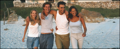 Photo: A group of young men and women walking on the beach.