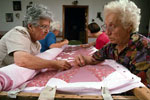 Two women working on a quilt.