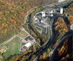 Aerial view of a school sports field near industrial buildings.