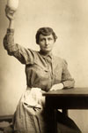 A woman holding a cup in her right hand.