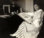 Woman with a sketch pad, seated at a desk.