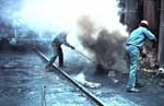 [Image: Workers on top of a coke oven. Work on top of coke ovens is known to cause lung and skin cancer, and thought to cause kidney cancer.]