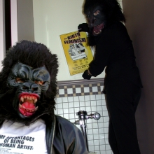 Guerrilla Girls, Photograph of Guerrilla Girls in bathroom with sign, "The Birth of Feminism". Courtesy of the Guerrilla Girls