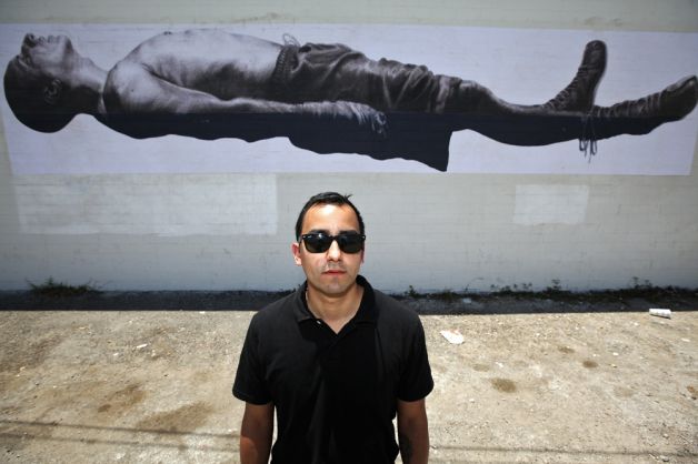 Vincent Valdez stands in front of his piece "Death of the Prizefighter" outside of the Family Dollar store next to the Guadalupe Gallery. ANDREW BUCKLEY / EXPRESS-NEWS