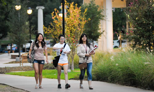photo of three TWU students strolling past the new Fitness & Recreation Center