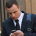 Oscar Pistorius checked his cellphone on Wednesday as he returned to court in Pretoria, South Africa.