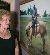 Donna Bird looks at a photo of her husband, Gary, who died during 9/11. She said he “rode a horse like his dad did. He and the horse were one.”<252><137>Donna Bird looks at a photo of her husband Gary, who died during 9/11, at her home in Tempe on Wednesday, September 10, 2014.<137><137><252><137>