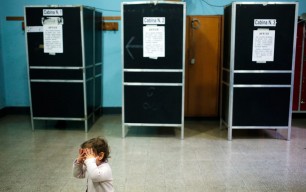 A child waits for her mother at a polling station in Rome, 24 February, 2013. Photo by Yara Nardi/Reuters