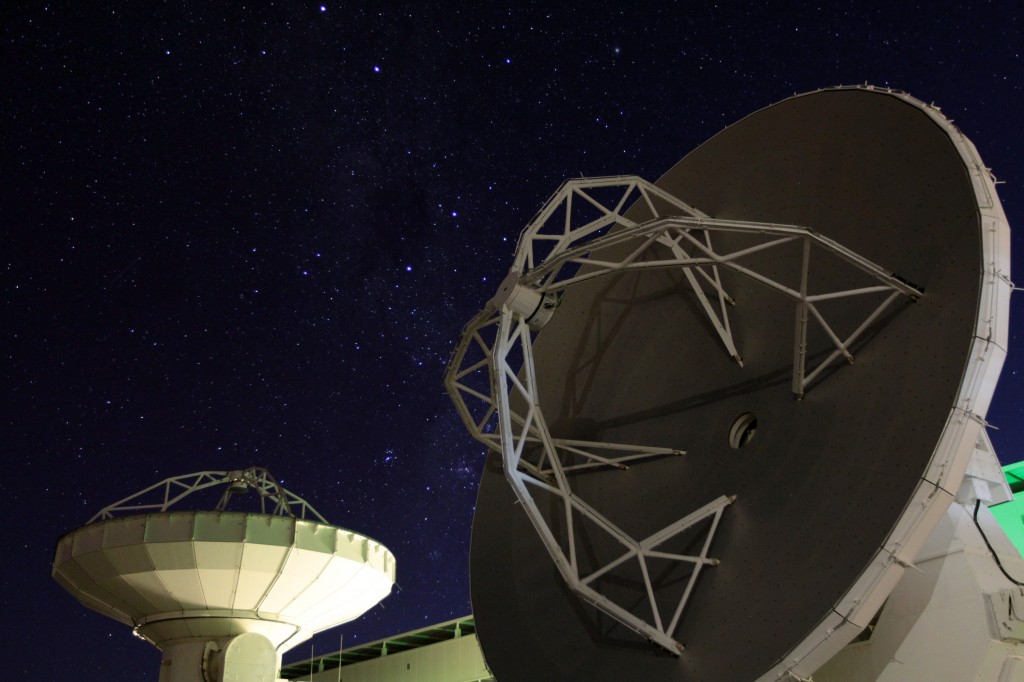 Two ALMA antennas facing different parts of the cloudless night sky. Photo by Joshua Barajas/PBS NewsHour