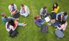 Group of students chatting together on the grass on campus