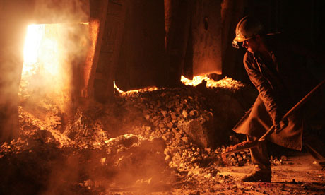 A worker throws coal into a smelting furnace