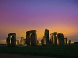 The lights of Amesbury set low-hanging clouds aglow over Stonehenge.