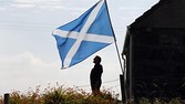 A Scottish Saltire flies in the garden of a cottage